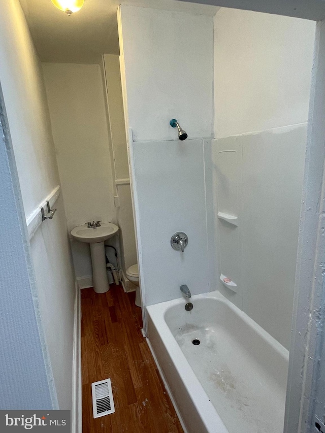 full bathroom with hardwood / wood-style floors, sink, bathtub / shower combination, and toilet