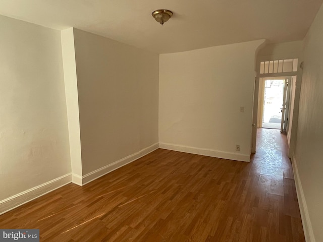 unfurnished room with dark hardwood / wood-style flooring