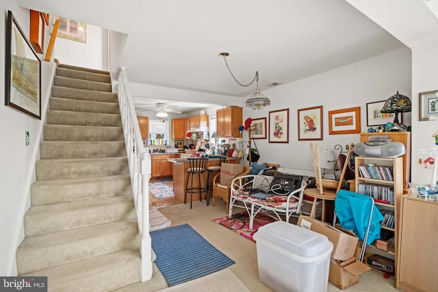 interior space featuring light colored carpet and ceiling fan