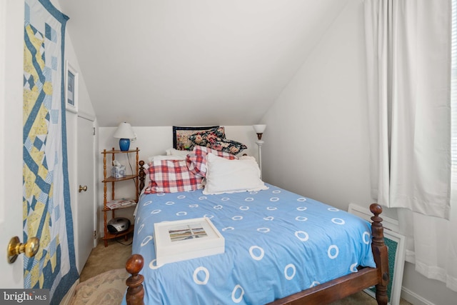 carpeted bedroom featuring lofted ceiling