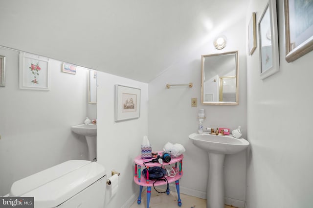 bathroom featuring lofted ceiling and toilet