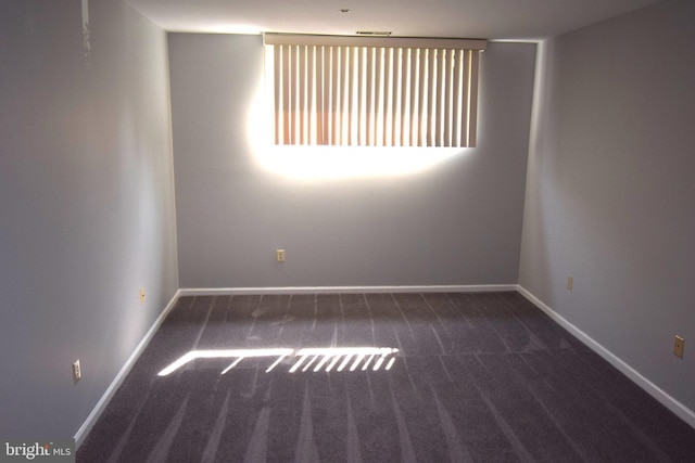 unfurnished room with dark carpet