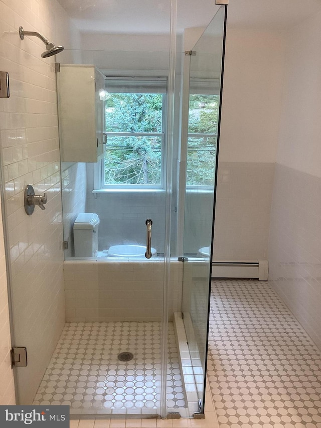 bathroom with a baseboard radiator, a shower with shower door, and tile patterned flooring