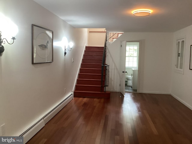 stairs featuring hardwood / wood-style flooring and baseboard heating