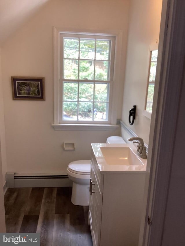 bathroom with lofted ceiling, hardwood / wood-style flooring, vanity, a baseboard heating unit, and toilet