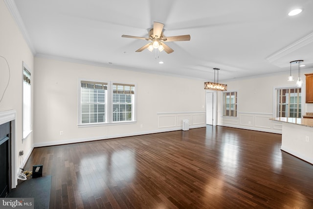 unfurnished living room featuring a wealth of natural light, ornamental molding, and dark hardwood / wood-style flooring