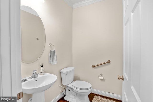 bathroom featuring sink, hardwood / wood-style floors, toilet, and ornamental molding