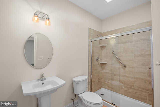 bathroom featuring sink, toilet, and a shower with door