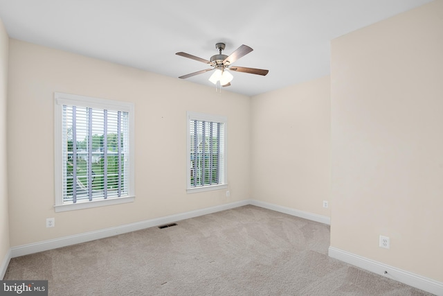 spare room featuring ceiling fan and light carpet