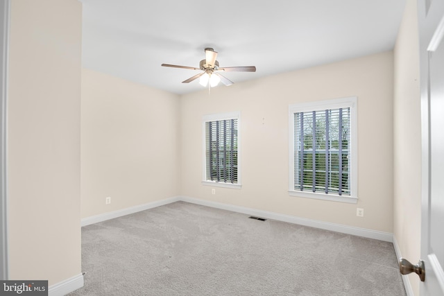 spare room with ceiling fan and light carpet