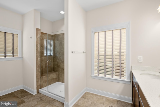 bathroom featuring a shower with shower door and vanity