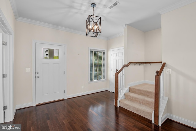 foyer entrance with crown molding, dark wood-type flooring, and a notable chandelier