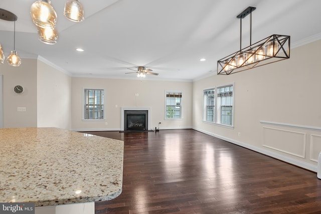 unfurnished living room featuring ceiling fan, crown molding, and dark hardwood / wood-style flooring