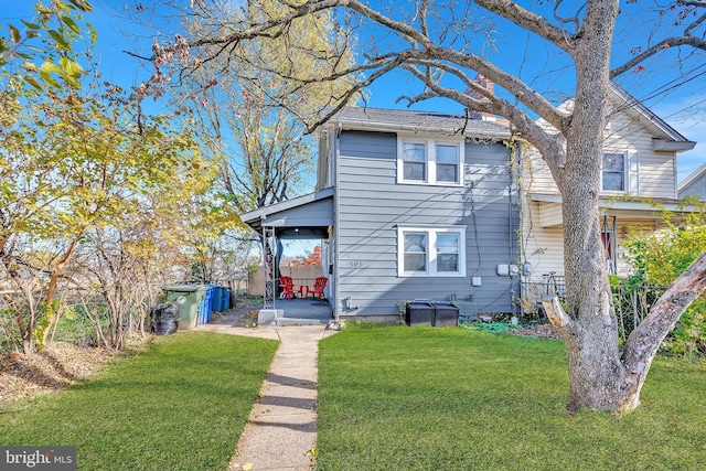 back of house with a lawn