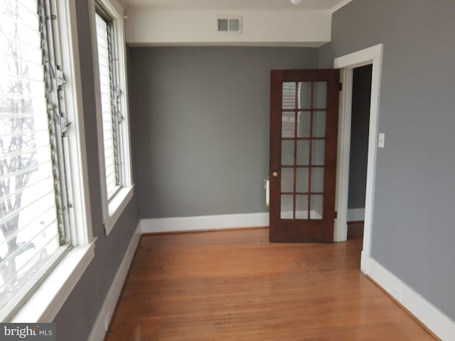 empty room featuring wood-type flooring and a healthy amount of sunlight