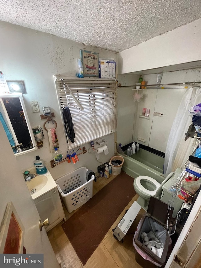 full bathroom with sink, shower / tub combo, toilet, and a textured ceiling