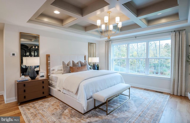 bedroom featuring a chandelier, coffered ceiling, light hardwood / wood-style floors, and beam ceiling