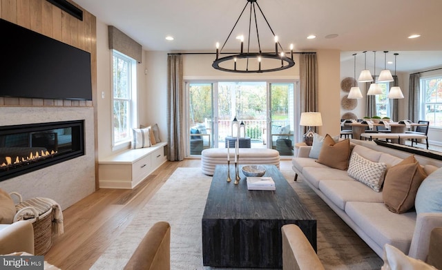 living room with light hardwood / wood-style flooring and an inviting chandelier