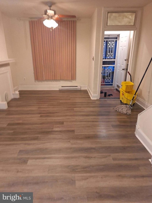 interior space with a baseboard heating unit, dark wood-type flooring, and ceiling fan