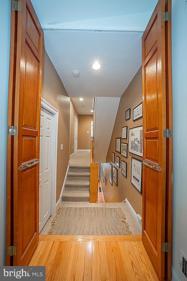 hall with light colored carpet