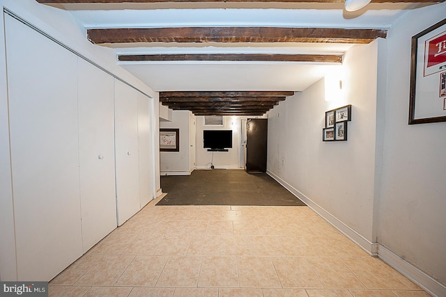 hall with beamed ceiling and light tile flooring