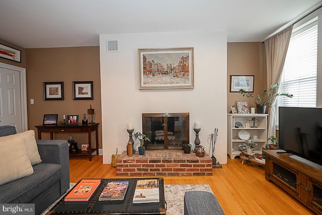 living room with light hardwood / wood-style flooring and a fireplace