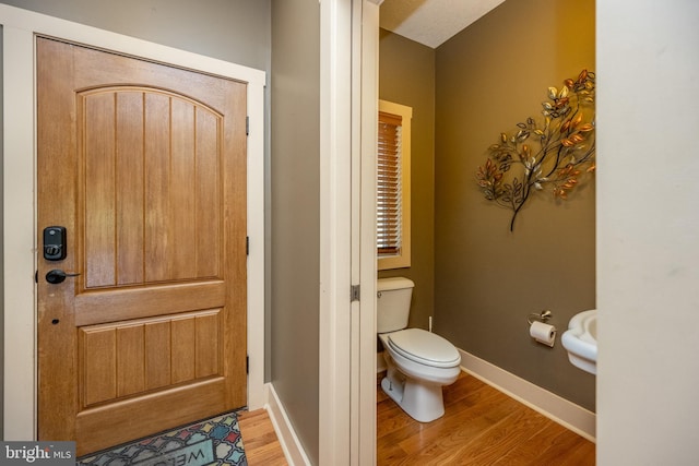 bathroom with toilet and hardwood / wood-style floors