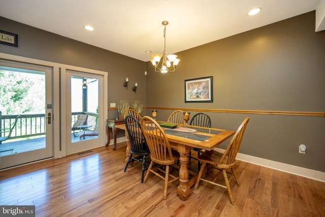 dining area featuring an inviting chandelier and light hardwood / wood-style floors