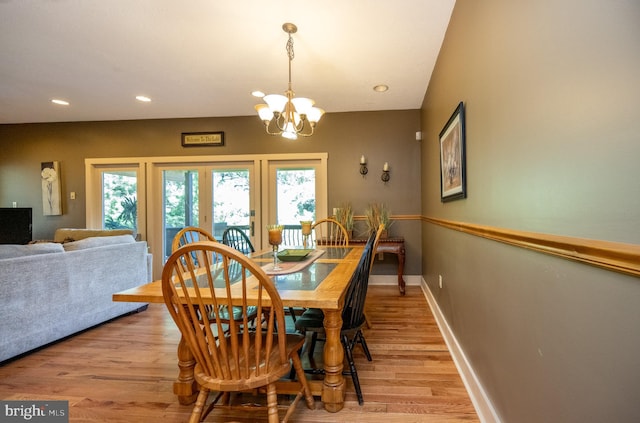 dining space with wood-type flooring and an inviting chandelier