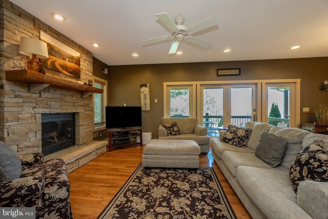 living room with hardwood / wood-style floors, ceiling fan, a fireplace, and plenty of natural light