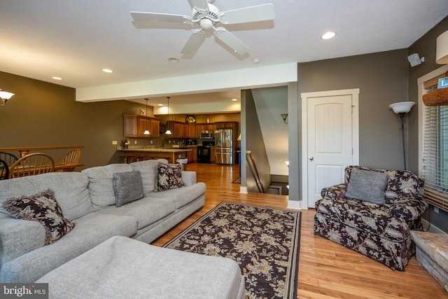 living room featuring light hardwood / wood-style flooring and ceiling fan