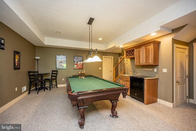 recreation room with light colored carpet, bar, pool table, and a tray ceiling