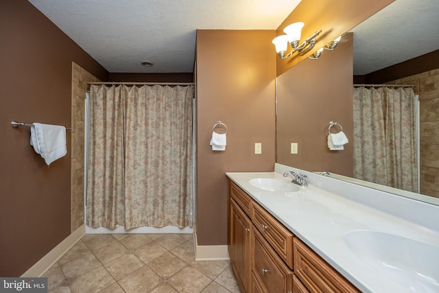 bathroom featuring dual sinks, tile floors, a textured ceiling, and large vanity