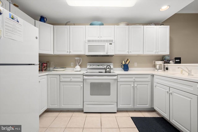 kitchen featuring light tile patterned flooring, sink, white appliances, and white cabinetry