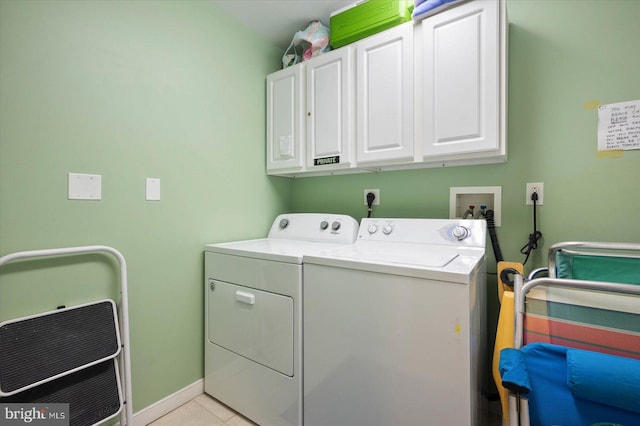 laundry room with light tile patterned floors, cabinets, and washer and dryer