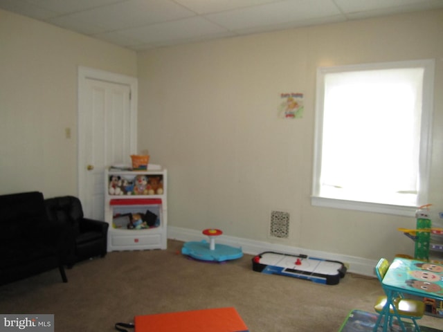 playroom featuring carpet flooring and a paneled ceiling