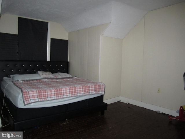 bedroom featuring dark hardwood / wood-style floors and lofted ceiling