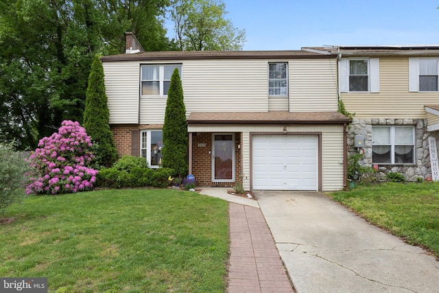 townhome / multi-family property with a garage and a front yard