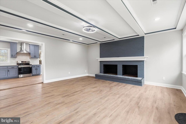 unfurnished living room featuring brick wall, light hardwood / wood-style floors, and a fireplace