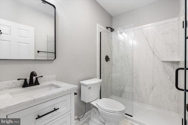 bathroom with a shower with door, vanity, and toilet