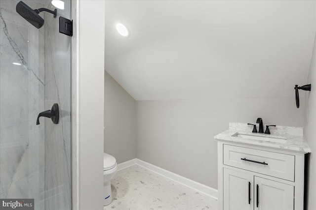 bathroom featuring toilet, vanity, vaulted ceiling, and a tile shower