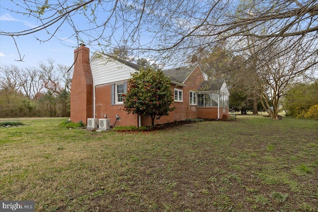 view of property exterior with a yard and central air condition unit