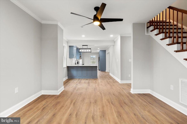 unfurnished living room featuring crown molding, light hardwood / wood-style floors, ceiling fan, and sink