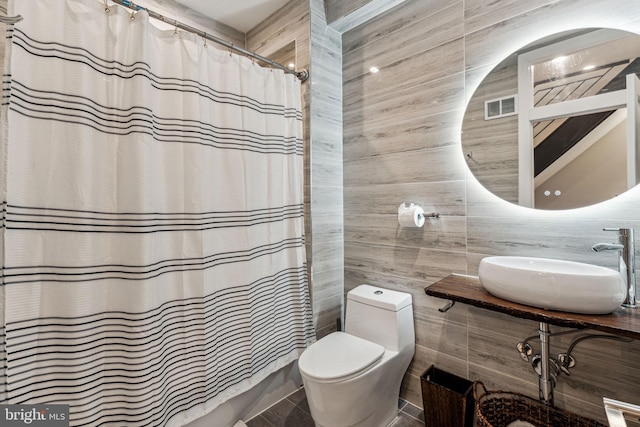 bathroom featuring tile walls, tile flooring, sink, tasteful backsplash, and toilet