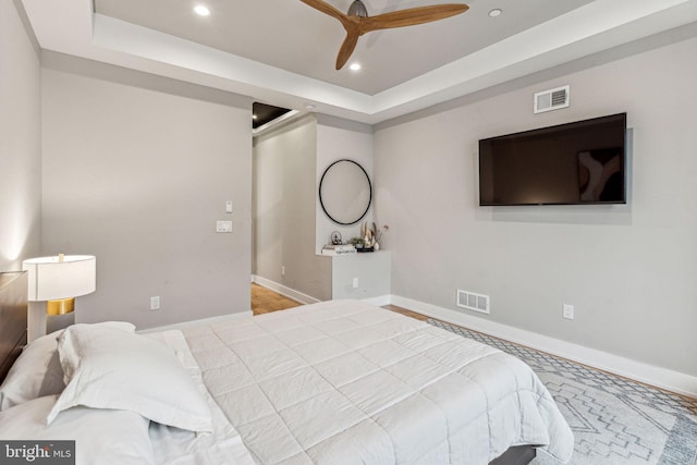 bedroom featuring carpet, ceiling fan, and a tray ceiling