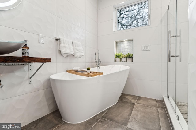 bathroom featuring tile walls, separate shower and tub, and tile floors