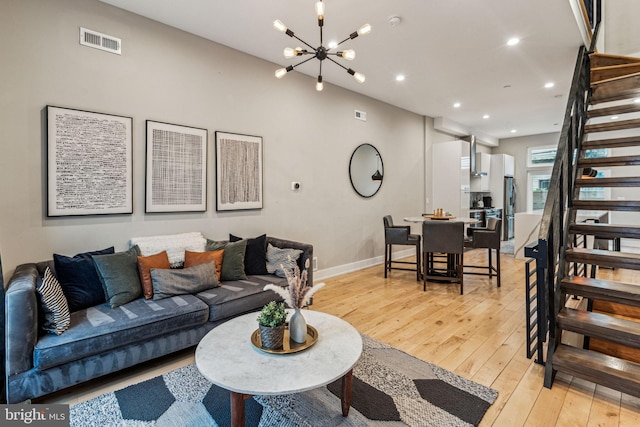 living room with an inviting chandelier and light wood-type flooring