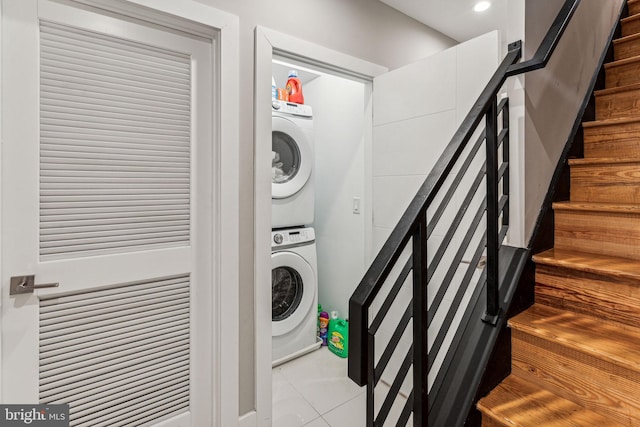 laundry area featuring stacked washer / dryer and light tile floors