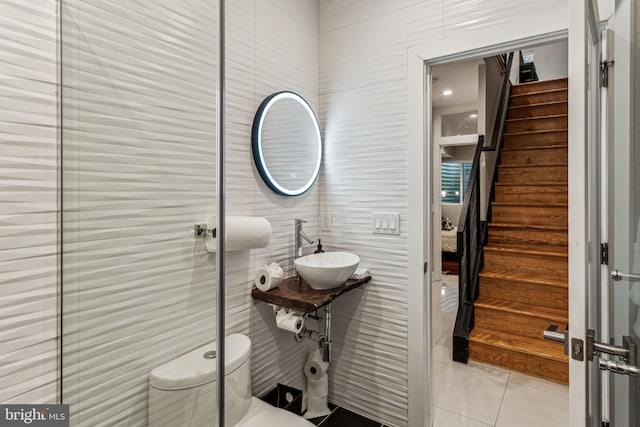 bathroom featuring sink, toilet, and tile flooring