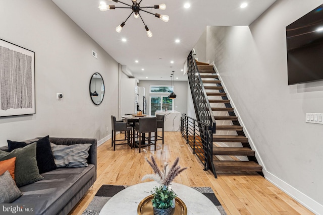 living room featuring light hardwood / wood-style floors and a notable chandelier